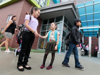 Third grader, Angelique Miraguentes, 9, assures her sister, and new student, Arlette Mirafuentes, 5, that eveyting will be alright as they prepare to enter the Irwin Jacobs elementary school in the south end of New Bedford on the first day of school.   [ PETER PEREIRA/THE STANDARD-TIMES/SCMG ]